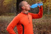 Ein männlicher Sportler trinkt ein blaues isotonisches Getränk. Ein männlicher Sportler trinkt ein blaues isotonisches Getränk.